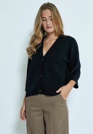 Black cardigan with a deep V-neck, short sleeves, and two front pockets. Made from a soft fabric, fitted design, and button closure.
