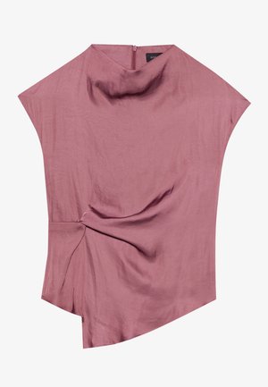 Blouse asymétrique en rose poussiéreux, en tissu léger. Présente un détail torsadé à la taille et un col montant subtil avec une fermeture éclair au dos.