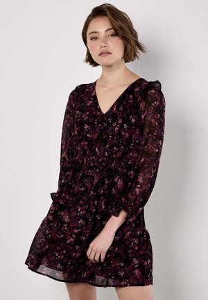 Schwarzes Kleid mit floralen Mustern in lila und rosa Tönen. Mit V-Ausschnitt, langen Ärmeln und gerüschtem Bund. Leichter Stoff.
