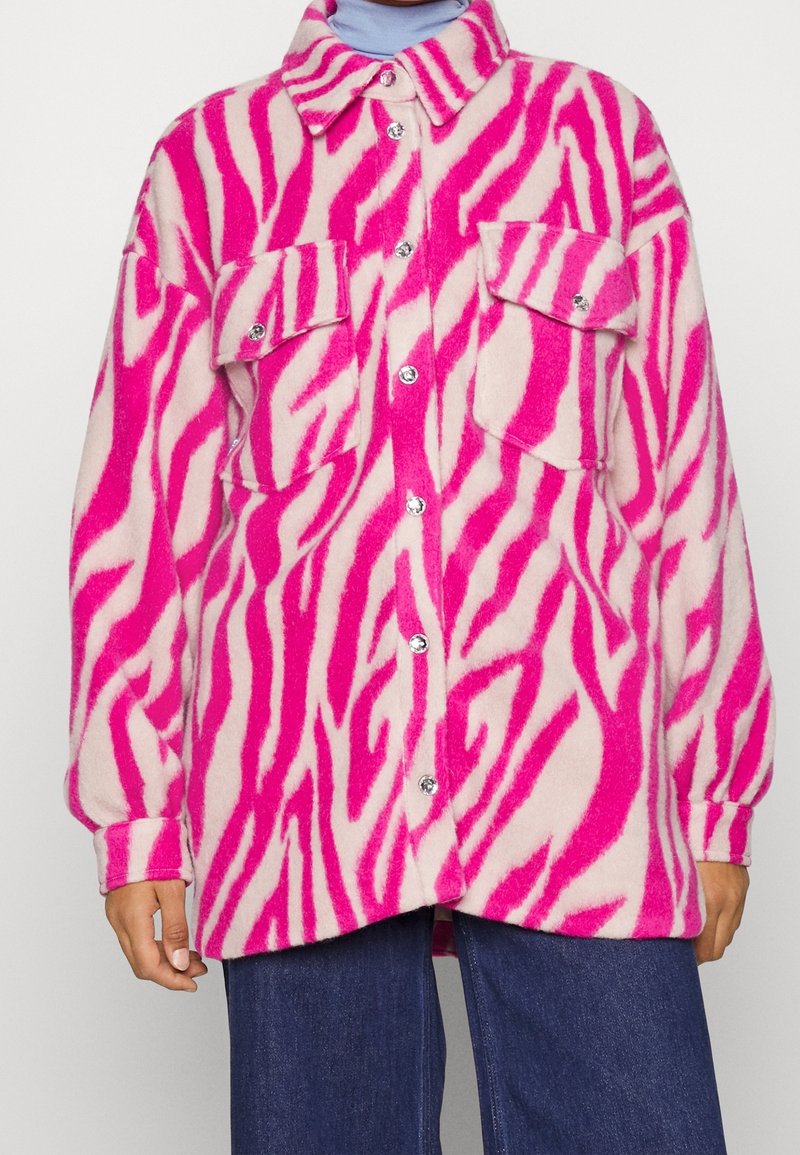 Rosa och krämfärgad oversize skjortjacka i zebramönster, med två framfickor, metallknappar och mjukt, lurvigt material.