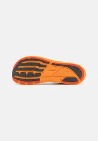 Semelle de chaussure avec un design ondulé aux couleurs noire, orange et rouge. Caoutchouc texturé pour une meilleure adhérence, avec des motifs de semelle distinctifs.