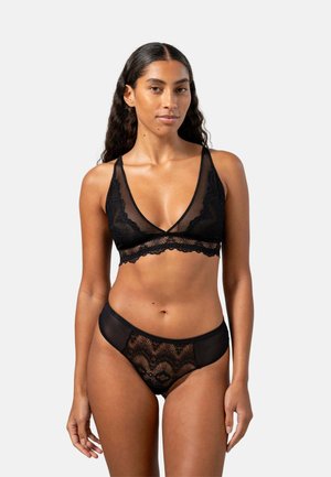 Zwarte kant bralette en bijpassende slipjes, doorzichtig materiaal, gegolfde randen en intricato golfpatronen. Eenvoudig ontwerp met verstelbare bandjes.