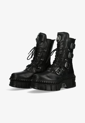 Bottes plateformes en cuir noir avec un laçage avant, trois boucles ajustables, semelle striée et finition texturée. Bout arrondi et fermeture éclair sur le côté.