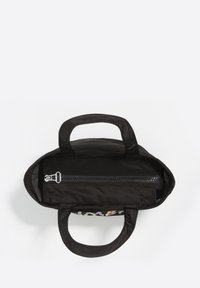 Czarna torba typu tote o tkaninowej fakturze; posiada dwa uchwyty i zamykaną na zamek komorę. Wnętrze jest przestronne i nie ma widocznych wzorów.