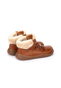 Botas de tobillo de cuero marrón con forro de lana beige, cordones en la parte frontal y suela de goma texturizada, mostradas desde un ángulo lateral trasero.