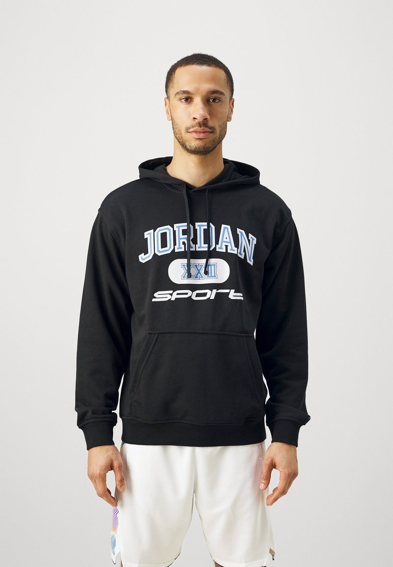 Sudadera negra con el texto "JORDAN" y "deportes" en azul y blanco. Presenta una capucha con cordón y un bolsillo canguro en la parte frontal.