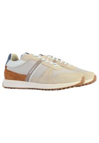 Baskets de sport beige avec des matériaux en suede et en mesh, accents en cuir tan contrastants, semelle blanche et détails réfléchissants sur les lacets.