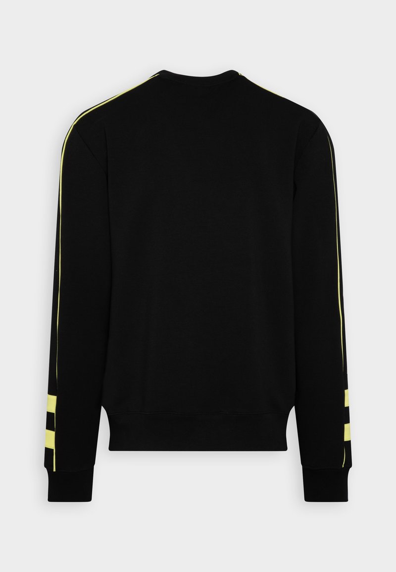 Sweat-shirt noir avec des manches longues, des poignets côtelés et de larges rayures jaunes le long des épaules et des manches. Tissu doux au toucher.