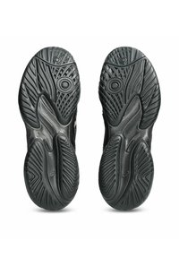 Schwarze Sportschuhsohlen mit strukturierten Profilmustern, kreisförmigen Rillen und ausgeprägten Kanälen für Grip und Flexibilität.