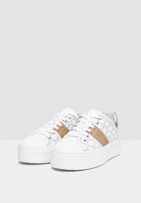 Zapatillas blancas con un upper de patrón, acentos beige y una suela gruesa blanca. Presenta cordones y detalles en tono plateado.