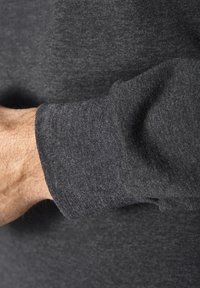 Grauer Sweatshirtbund mit einer weichen Textur und geripptem Finish. Der Stoff wirkt leicht gesprenkelt und vereint dunkle und helle Grautöne.