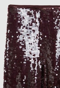 Tissu en sequins bordeaux, densement recouvert de sequins ronds de tailles variées, créant une surface brillante et texturée avec des accents réfléchissants.