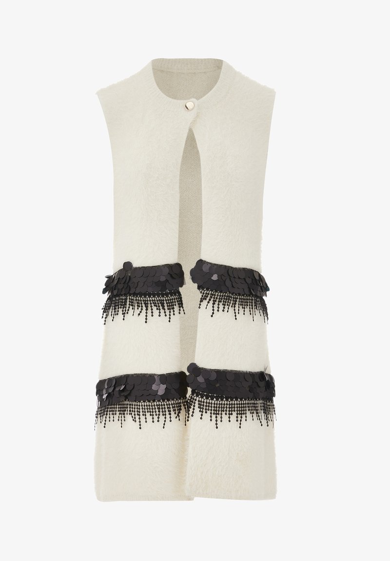 Cream-colored sleeveless vest with a fuzzy texture, featuring two black sequin and fringe embellishments at the waist and a front button closure.