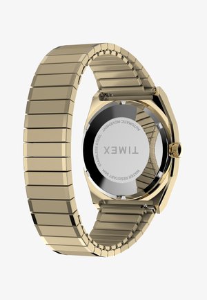 Ρολόι χειρός Timex σε χρυσό τόνο με μεταλλικό λουρί από κρίκους, δείχνοντας την πίσω πλευρά από ανοξείδωτο ατσάλι με χαραγμένο το σήμα, την αντοχή στο νερό και τις λεπτομέρειες του αυτόματου μηχανισμού.