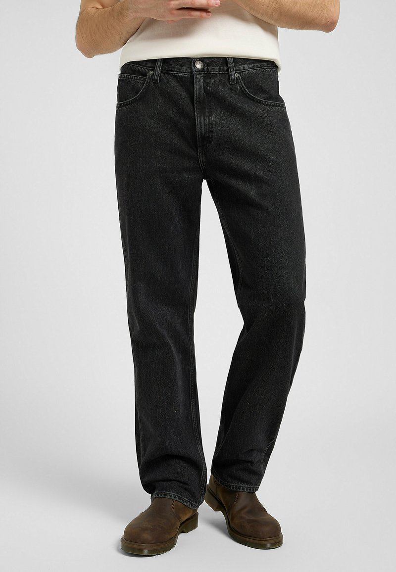 Svarte denim jeans med avslappet passform, fem lommer, synlig søm og rette ben. Brukt sammen med brune støvler.