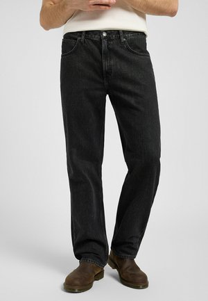 Zwarte denim jeans met een relaxte pasvorm, vijf-pocket ontwerp, zichtbare stiksels en een rechte pijp. Gdragen met bruine laarzen.