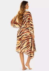 Płynący szlafrok z szyfonu z pomarańczowym i brązowym wzorem w paski tygrysa, asymetrycznym dołem i szerokimi rękawami. Związany w talii.