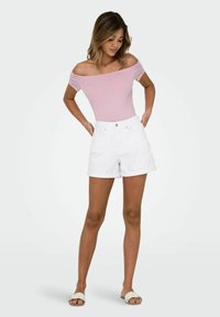 Lyserød off-shoulder bodysuit med korte hvide denimshorts. Glat stof, tætsiddende design, rulletkant på shortsene og åben-tå sandaler.