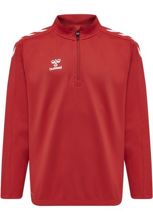 Giacca in felpa rossa con colletto alto, zip frontale a metà e dettagli bianchi a forma di chevron lungo le maniche. Logo visibile sul petto.