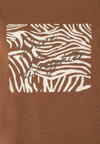 Bruine stof met een witte zebra-printpatroon en textuurelementen. Scripttekst "Live Brighter" is versierd met kleine rhinestones.