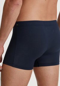 Navy blue boxer shorts made from soft fabric, featuring a stretchy waistband and minimal stitching details for a smooth finish.