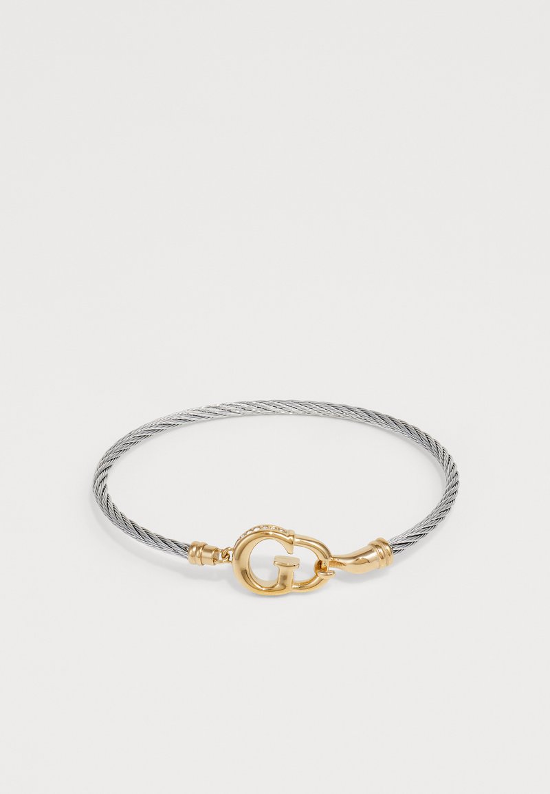 Ezüst színű, kábelstílusú karkötő arany színű csattal, amelyen egy 'G' logo található, sima textúrával és finom részletezéssel a széleken.