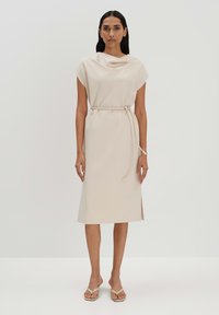 Beiges Midi-Kleid mit Schalkragen, kurzen Ärmeln und einem Bindegürtel in der Taille. Verfügt über einen seitlichen Schlitz für Bewegungsfreiheit und eine glatte Textur.