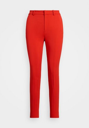 Czerwone dopasowane spodnie o gładkiej fakturze, z prostym przodem, pętelkami na pasek i zwężanym krojem nogawki. Brak widocznych wzorów lub detali metalowych.
