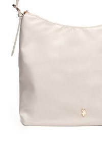 Beige syntetisk handväska med slät yta, dragkedjestängning och en gyllen accentlogotyp. Har ett enda axelrem för enkel bärning.