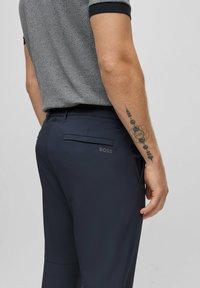 Marina byxor med en elegant, skräddarsydd design. Har en bakficka med präglad "BOSS" logotyp och slät tygfinish.
