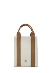 Borsa tote in tela color crema con manici in pelle marrone. Presenta un piccolo logo a forma di teschio al centro in basso e una forma rettangolare strutturata.