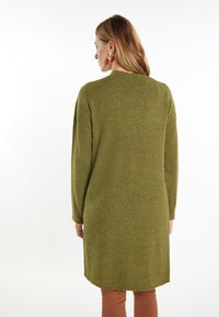 Maglione verde oliva con vestibilità comoda, maniche lunghe e scollatura arrotondata. Tessuto morbido e spacchi laterali all'orlo per facilitare i movimenti.