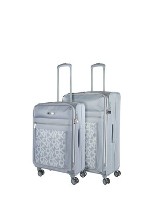 Juego de equipaje de policarbonato gris claro que incluye dos tamaños, superficies lisas, bolsillo frontal con cremallera y patrón de logotipo, y cuatro ruedas para movilidad.