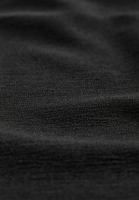 Tessuto nero con una superficie liscia, caratterizzato da leggere variazioni nella consistenza e da un sottile motivo di trama, creando un aspetto morbido e flessibile.