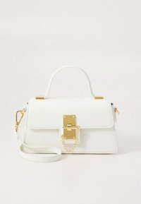 White crossbody bag with textured faux leather, gold hardware, a top handle, and a removable strap. Features a clasp closure with a chain detail.