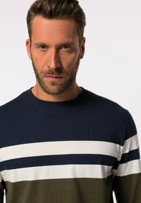 Camisa de manga larga azul marino con rayas blancas y verde oliva, cuello redondo y logotipo en relieve en el pecho. Material de mezcla de algodón.