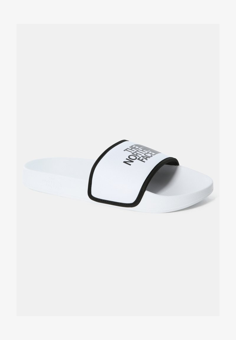 White slide sandal with a black border and a wide strap displaying "THE NORTH FACE" in bold gray lettering on the upper surface. Smooth texture.