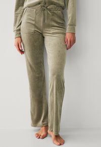 Velvet sweatpants in gedempt olijfgroen. Voorzien van een trekkoord in de taille, twee steekzakken en een zachte, gladde textuur. Taillering, ontspannen pasvorm.