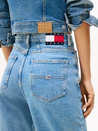 Jeans din denim de un albastru deschis, cu o etichetă din piele maro și o etichetă cu logo multicolor pe talie. Design clasic cu cinci buzunare.