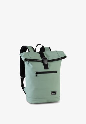 Mochila enrollable de color verde claro con bolsillo frontal con cremallera, correas ajustables negras y cierre de hebilla negra, etiqueta de la marca Bench en la parte frontal.