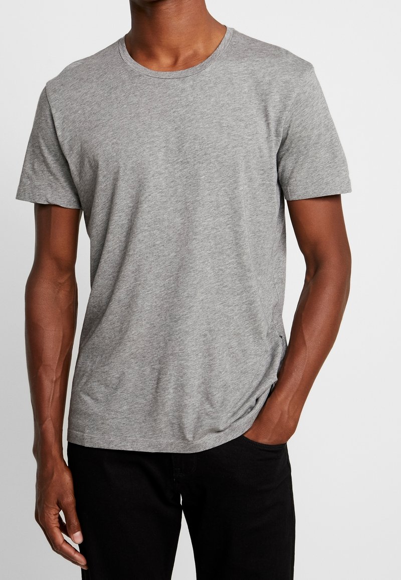 Grå kortærmet T-shirt lavet af blød bomuldsblanding, med en klassisk rund halsudskæring og en afslappet pasform. Sømme langs siderne.