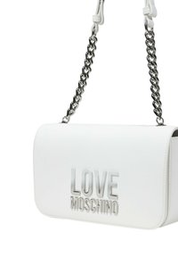 Borsa a spalla in finta pelle bianca con patta, tracolla in catena argentata e logo "LOVE MOSCHINO" in rilievo sul fronte. Texture liscia.