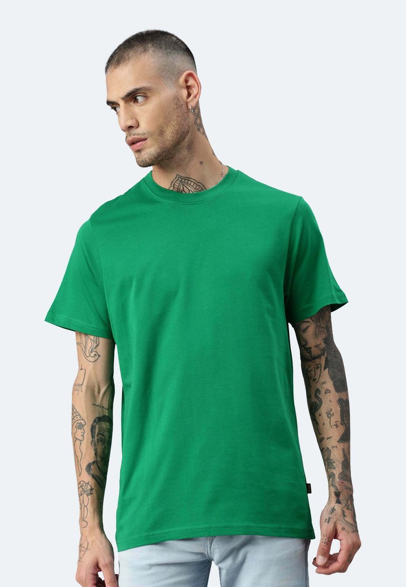 T-shirt in cotone verde con un classico scollo rotondo e maniche corte; presenta una vestibilità rilassata e una consistenza liscia.