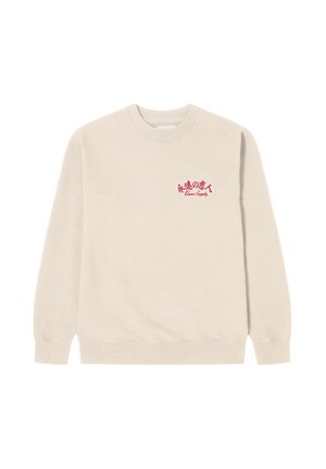 Sudadera beige hecha de tejido suave, con cuello redondo y puños acanalados, con un logotipo de texto rojo en el lado izquierdo.