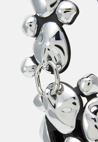 Silver-colored accessory featuring smooth, reflective surfaces, cohesive organic shapes, and black accents. Includes a connecting metal ring.