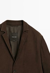 Blazer in suede marrone con rever a punta, chiusura a un bottone e foderato all'interno. L'etichetta riporta "Massimo Dutti" in un testo bianco brillante.