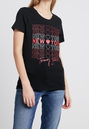 Czarny t-shirt z krótkim rękawem zdobiony nadrukiem z powtarzającym się napisem "NEW YORK" oraz motywem serca, w połączeniu z niebieskimi dżinsami.