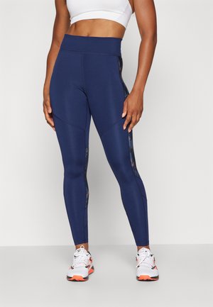 Mørkeblå høyt liv leggings med et blomstrete sidestykke, laget av elastisk stoff, med stikningsdetaljer og en glatt tekstur.
