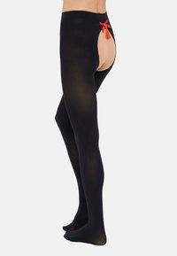 Črne najlonke z izrezanim hrbtom in nude panelom, okrašene z rdečo pentljo in detajlom s frufruji. Mehek material in gladka površina.