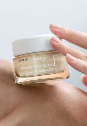 Crème de nuit réparatrice au pin blanc de Korres dans un pot en verre transparent avec un couvercle blanc. Contient un produit léger et crémeux. Étiquettes à l'avant.